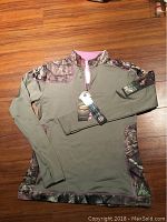 Full image of women's Yukon Gear jacket showing camouflage accents, quarter zip, and tag.