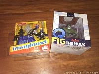 Photo of two boxed items: Fisher-Price ImagineXt knight and horse toy set, and Qmx Avengers FiG The Hulk collectible figure