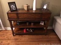 Full frontal view of sofa table showing top surface, single drawer and two open shelves below