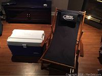Bud Light folding chair with cooler set on wooden floor indoors, showing front view of chair and cooler.