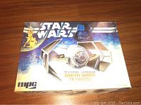 Top view of box showing Star Wars artwork including Darth Vader and the T.I.E. Fighter labeled as authentic Darth Vader T.I.E. Fighter by MPC.