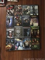 Photo showing 16 sci-fi DVD cases arranged in four rows featuring Spawn, The Proposal, Van Helsing, Underworld, AVP, Iron Man 2, X-Men Origins, Beetlejuice, and others.