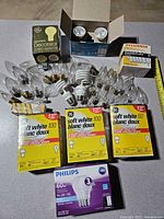 Overall lot showing boxed GE, Philips, Sylvania bulbs plus loose bulbs
