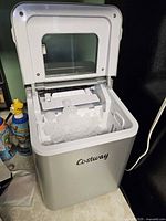 Lid open showing produced bullet ice in basket