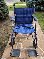 Full view of wheelchair showing frame, upholstery, footrests