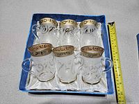 Six tea cups in presentation box, top view with measuring tape