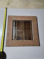 Front view of square mirror with measuring tape for scale