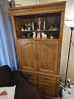 Full view of oak entertainment center showing hutch, doors, drawers, hardware and finish