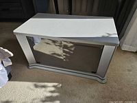 Front view of silver/gray TV stand with closed glass doors