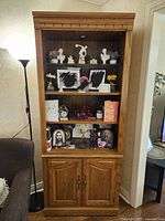 Full view of lighted oak display cabinet with doors closed