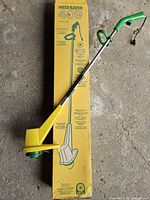 Full view of Weed Eater 409 trimmer placed beside its box