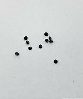 Group of 10 small round black diamonds on white background