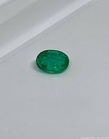 Emerald resting on flat surface showing overall color and shape