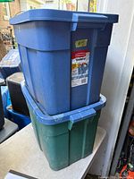 Blue and green Roughneck totes stacked with lids