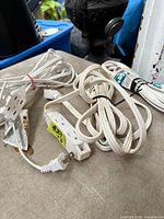 Three bundled white extension cords with three-outlet blocks