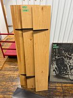 Three wood shelves leaning against wall showing brackets and surface