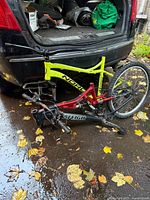 Both bicycle frames on ground behind vehicle, showing Norco frame and Raleigh frame with rear wheel