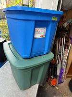 Blue HDX tote stacked on green tote, both with lids