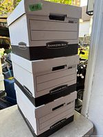 Three stacked Bankers Box 772 storage boxes with lids showing labeling panels and handles