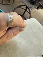 Ring on finger showing overall design and diamond setting