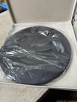 Platter inside open box with plastic sleeve