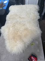 Top view of the white faux lamb rug laid flat on a table
