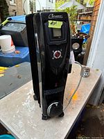 Full view of Garrison oil-filled space heater showing fins, control panel, power cord wrap