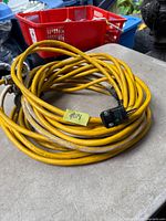 Coiled yellow extension cord with hospital-grade plug visible