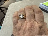 Ring on finger showing yellow gold band with diagonal diamond channels