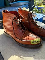 Oblique view of both boots showing leather uppers, brogue pattern, laces