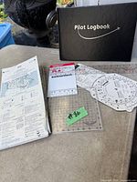 All items overview: logbook, flight computer, plotters, chart, booklet