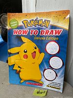 Front cover of Pokemon How To Draw Deluxe Edition book showing Pikachu graphic and publication details