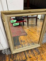 Front view of mirror showing gold wood frame and glass