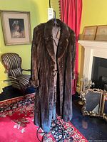 Front view of full-length mink fur coat on stand