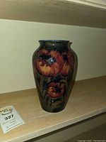 Front view of Moorcroft vase showing floral design and repair cracks