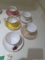 Top view of all six teacup and saucer sets displaying colours and patterns