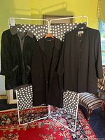 Front view of all three jackets hanging on rack