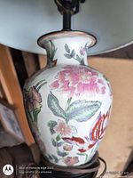 Close-up of ceramic vase body showing floral motif and lamp hardware