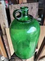 Front view of emerald green glass jug showing ring handle and flared lip