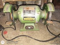 front view of bench grinder showing label, wheels, base and switch