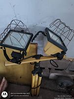 Full view of dual halogen work light on folded tripod