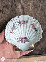 Front view of white scallop shell dish with floral design and gold accents