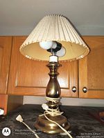 Full view of brass lamp with shade showing dual bulbs and cord