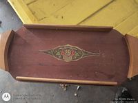 Top view of wooden tray showing full length, rails, floral motif
