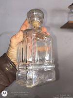 Front angled view of clear pressed glass decanter with stopper