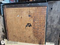 Top view showing wood grid base with wear and iron hinge