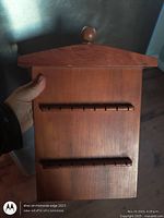 Front view of pine spoon rack with two slotted rows and peaked top