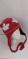 Front left three-quarter view of red earflap hat on mannequin head