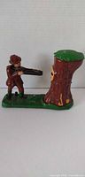 Full view of cast iron hunter & bear bank showing hunter aiming at tree stump