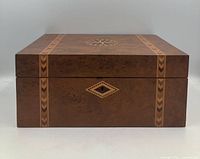 Closed bird's-eye maple sewing box front view showing inlay and escutcheon